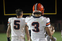 Seniors Nolan Hartford and Andrew Hellriegel walk towards the post game huddle after the win over Herrin.