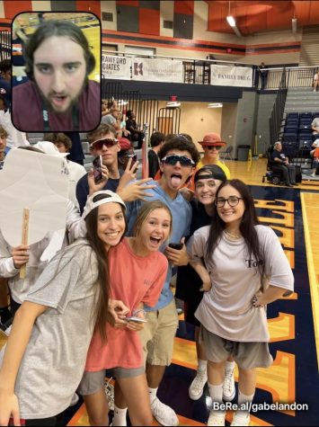 Junior Gabe Landon is taking a BeReal at a volleyball game with some of the Carterville Crazies members.
