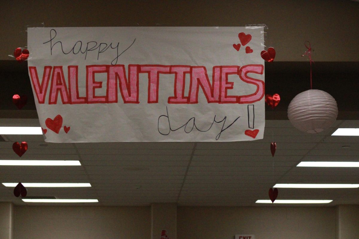 The+school+putting+up+a+Valentines+Day+banner+in+preparation+for+the+Valentines+Day+Banquet.
