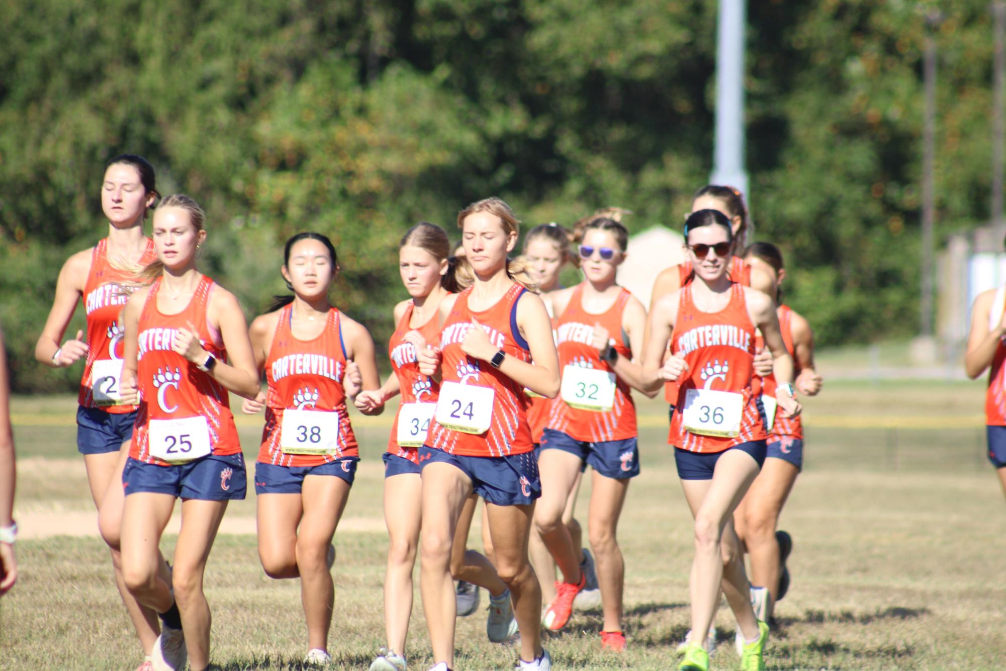 The girls cross country team running together for a warm up. 