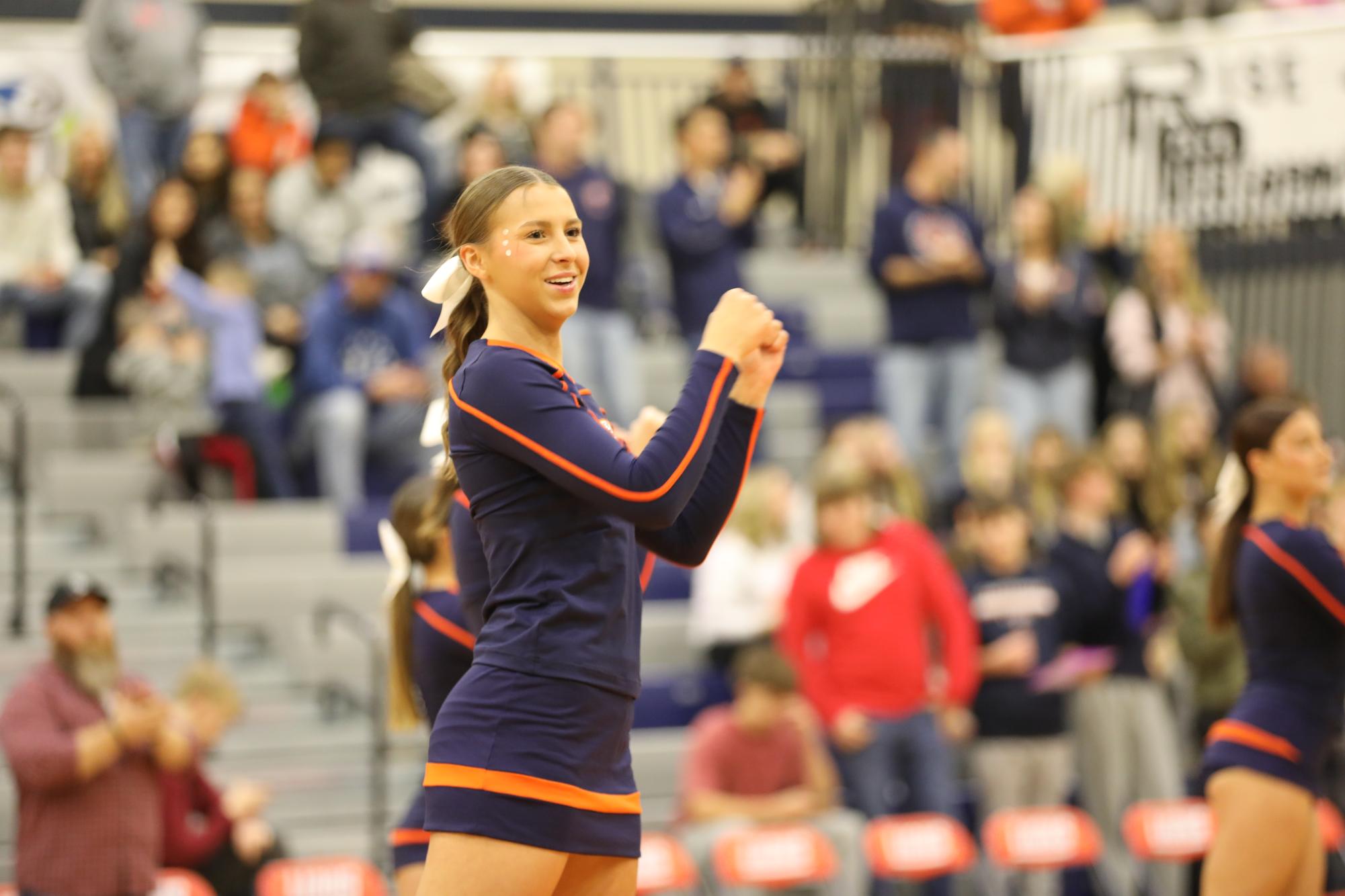 Senior Mercedes Levesque performs school song at a home basketball game.