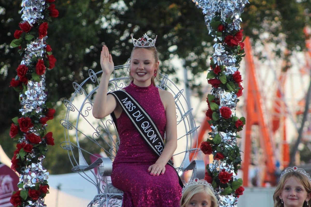 The Miss DuQuoin State Fair Queen riding through the Parade on Friday August 22. During the Parade there was candy thrown, and pictures got to be taken by multiple people.