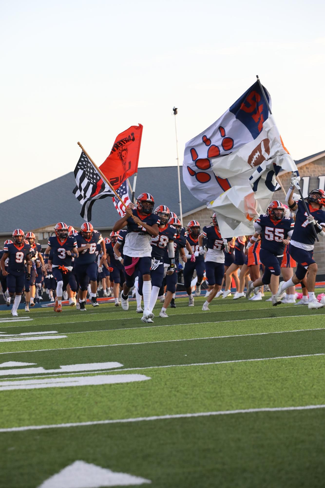 The football team is doing run-out at the beginning of the game. This was against Marion at Carterville on August 29.