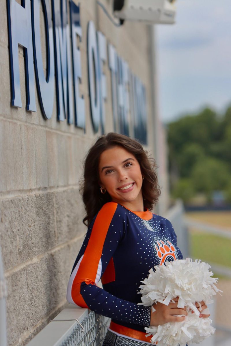 Senior Charlotte Williams smiles while standing in the bleachers at the "Home of the Lions" stadium.