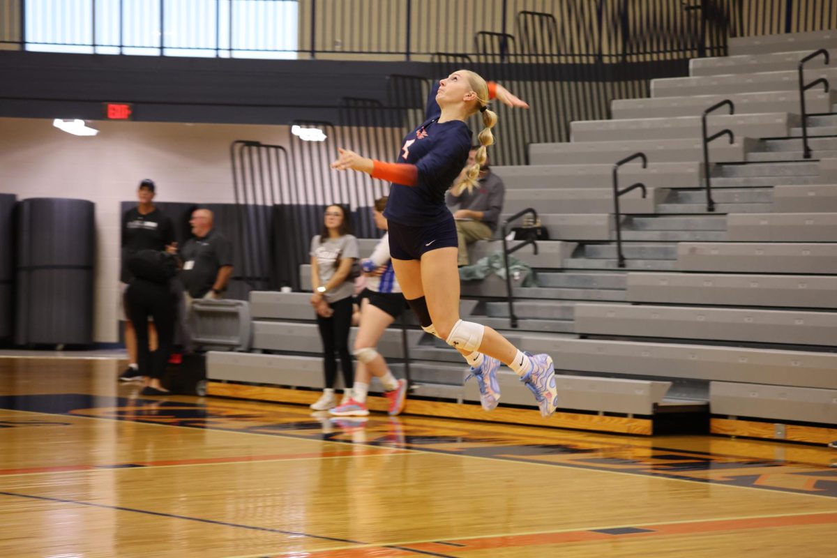 Senior Colbie Bennett jump serves to start off the game. 