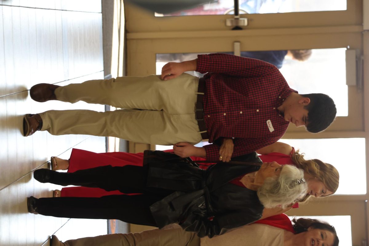 Sophomore Peter Barnstable walking a guest into the Valentine's Day Banquet to get signed in.
